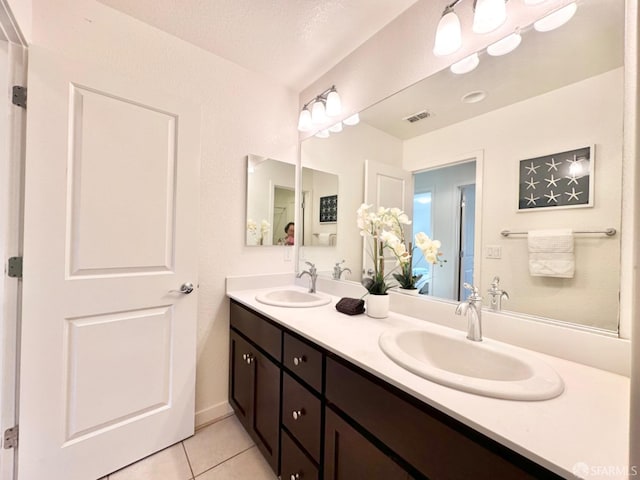 bathroom with vanity, a textured ceiling, and tile patterned floors