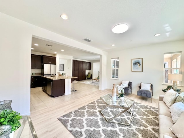 living room with light hardwood / wood-style floors and sink