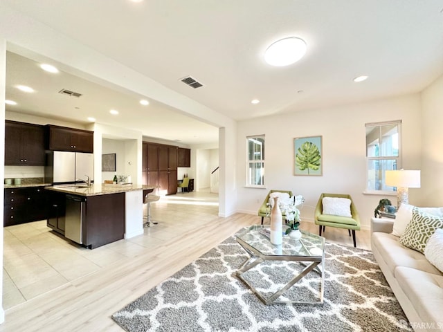 living room with sink and light hardwood / wood-style flooring