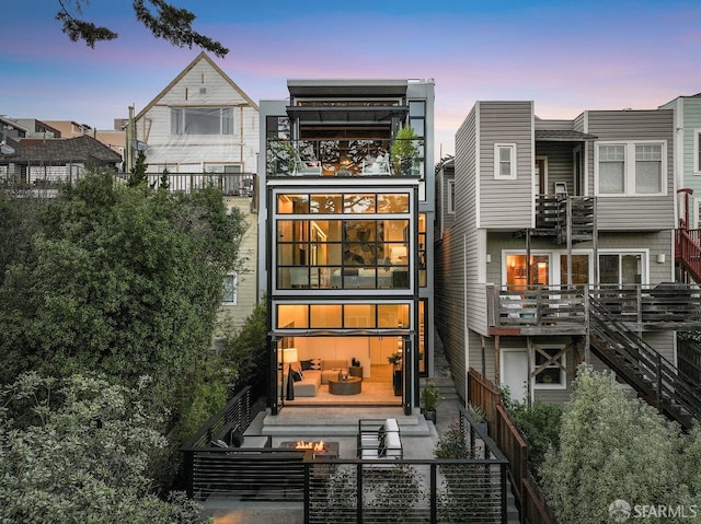 back house at dusk with an outdoor fire pit