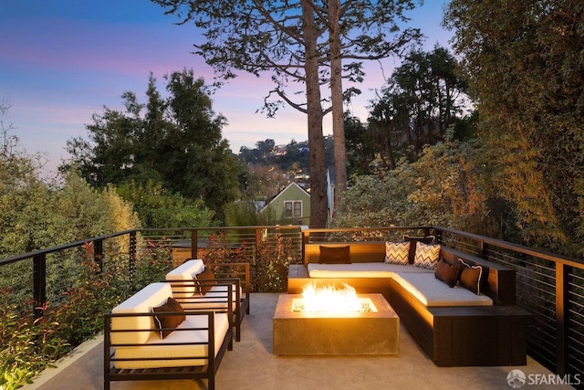 patio terrace at dusk with an outdoor living space with a fire pit