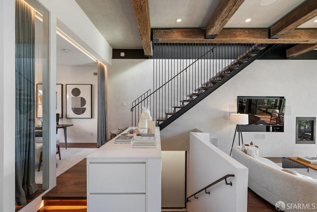 staircase with hardwood / wood-style floors and beamed ceiling