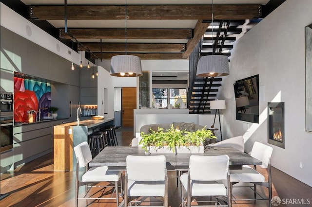 dining area with sink and beamed ceiling