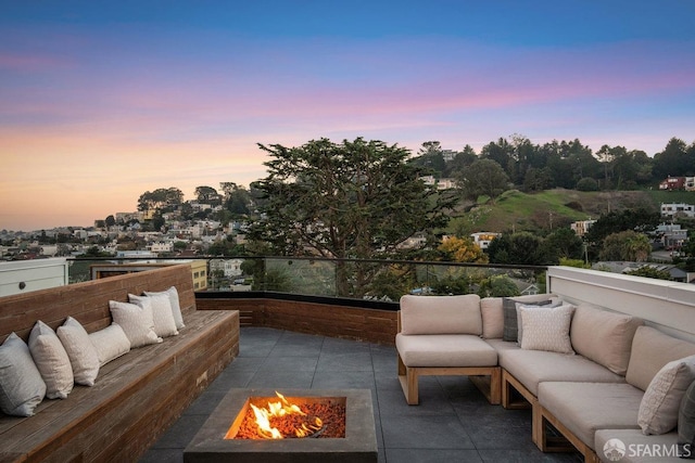 patio terrace at dusk with an outdoor living space with a fire pit