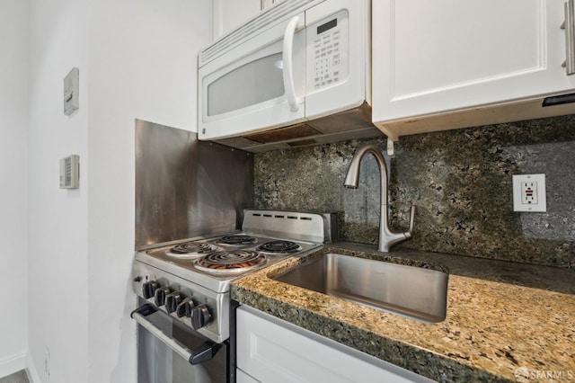 kitchen featuring white cabinetry, sink, dark stone countertops, decorative backsplash, and stainless steel stove