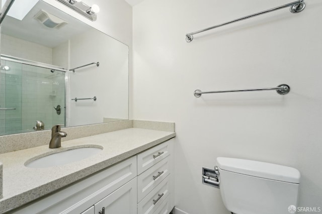 bathroom featuring vanity, toilet, and walk in shower