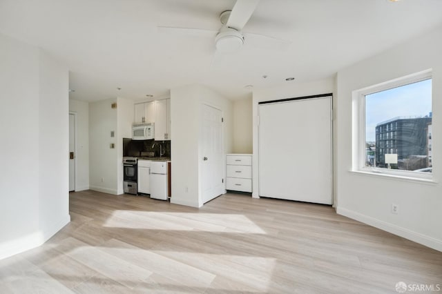 interior space with light wood-type flooring, ceiling fan, and sink