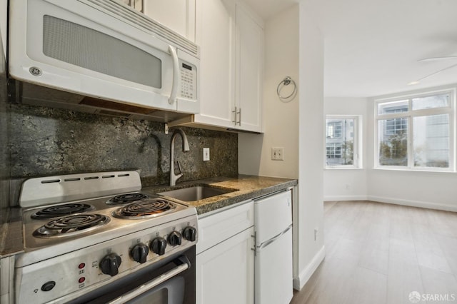 kitchen with white cabinets, decorative backsplash, white appliances, and sink