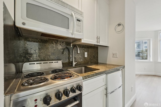 kitchen with backsplash, white cabinets, refrigerator, electric stove, and sink