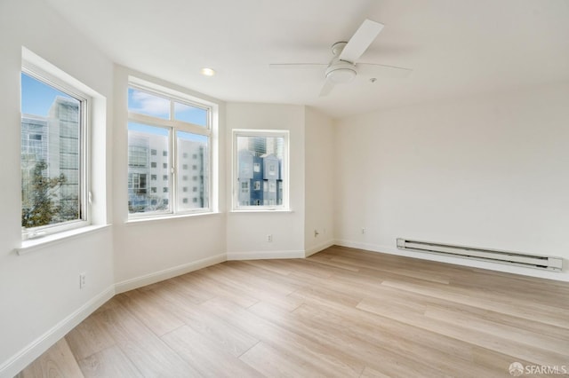 empty room featuring light wood-type flooring, baseboard heating, and ceiling fan