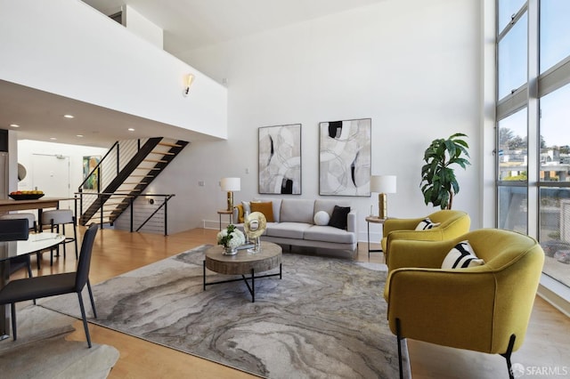 living room with a towering ceiling and light hardwood / wood-style floors