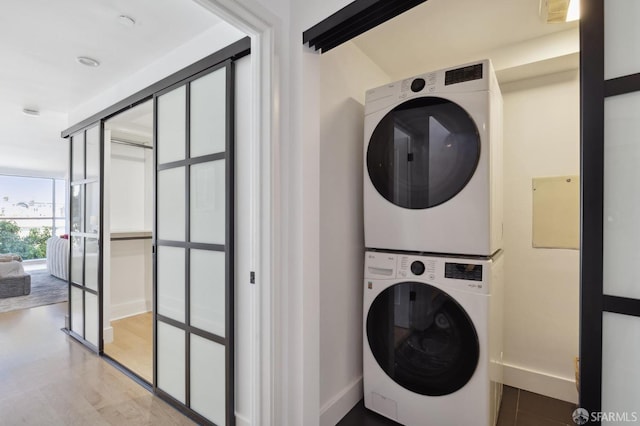 clothes washing area with stacked washer and clothes dryer