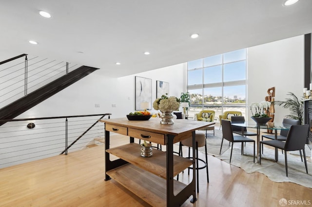 dining area with a wall of windows and light hardwood / wood-style flooring