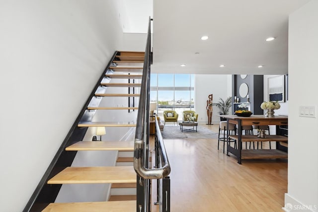 stairway featuring hardwood / wood-style floors and a wall of windows