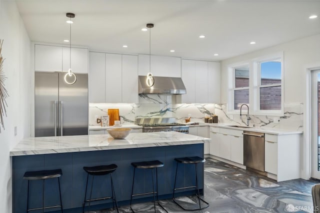 kitchen featuring extractor fan, pendant lighting, sink, white cabinets, and stainless steel appliances