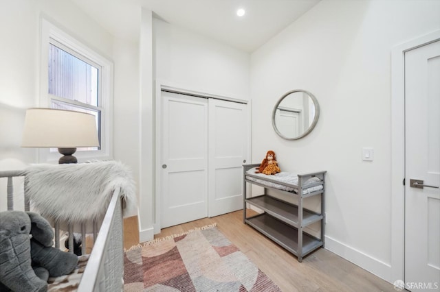 bedroom with light hardwood / wood-style floors and a closet