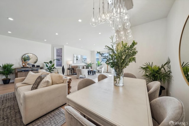 dining room with hardwood / wood-style floors and an inviting chandelier