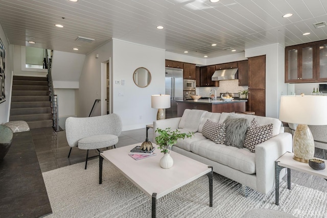 living room featuring stairs, baseboards, visible vents, and recessed lighting