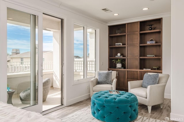 sitting room featuring baseboards, light wood-style floors, recessed lighting, and crown molding