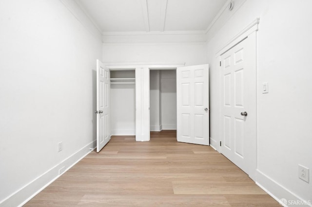 unfurnished bedroom featuring ornamental molding and light hardwood / wood-style floors
