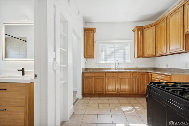 kitchen featuring sink, light tile patterned floors, and black range with gas stovetop