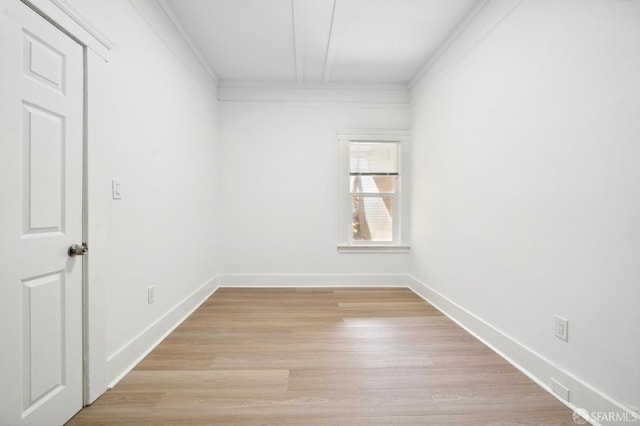 spare room with ornamental molding and light hardwood / wood-style floors