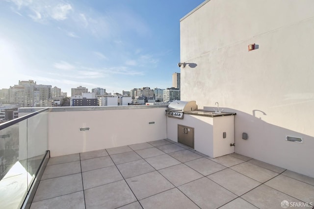 view of patio / terrace featuring area for grilling, sink, and a balcony