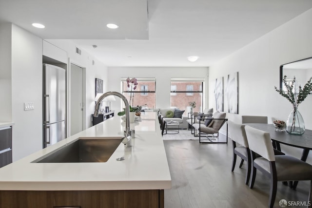 kitchen with sink, stainless steel refrigerator with ice dispenser, and wood-type flooring