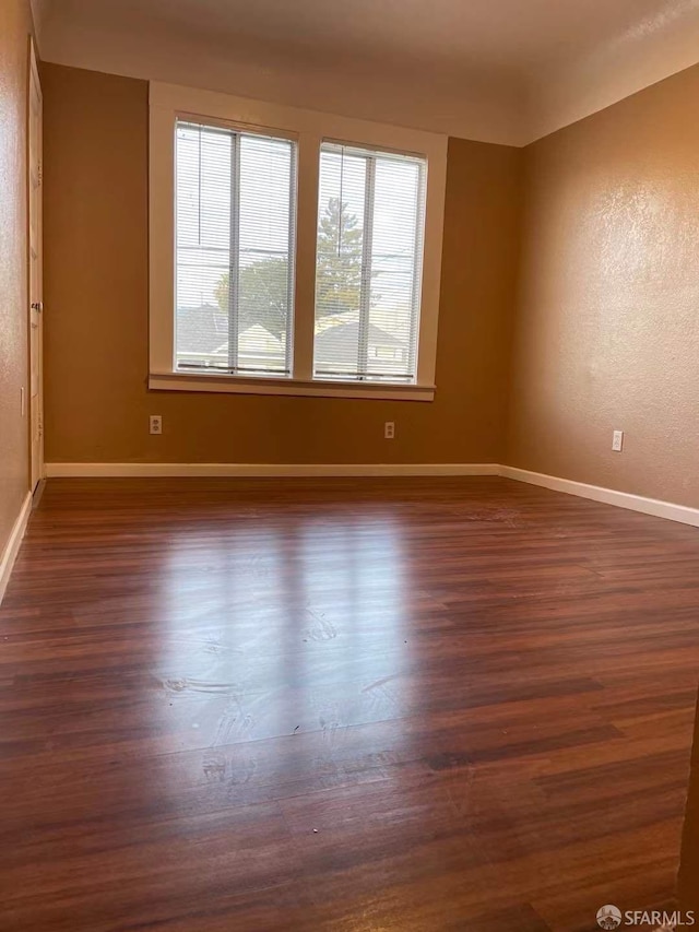 empty room with dark hardwood / wood-style flooring