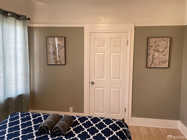 bedroom featuring ornamental molding and hardwood / wood-style floors