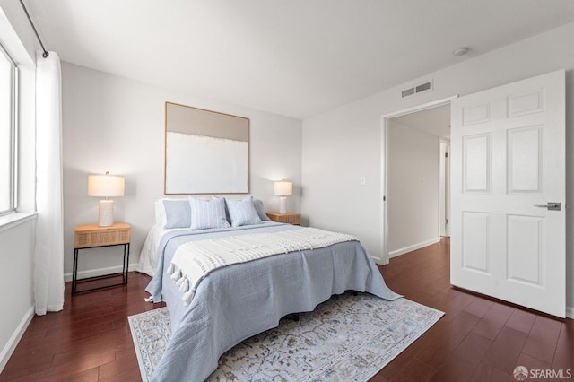 bedroom featuring dark wood finished floors, baseboards, and multiple windows