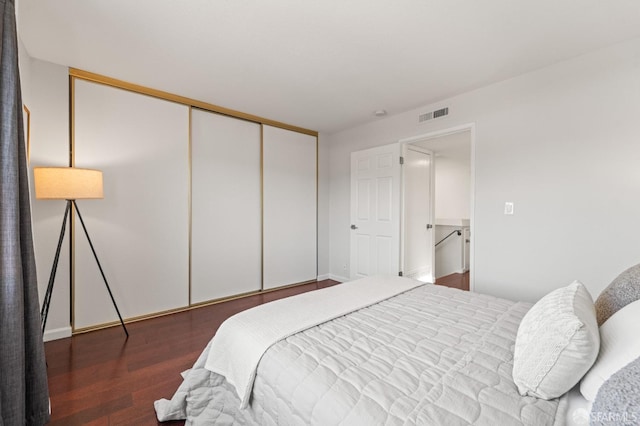 bedroom featuring wood finished floors, a closet, and baseboards