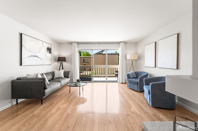 living area with light wood-style flooring and baseboards