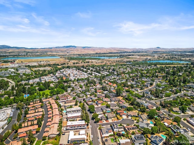 view of property location featuring a water and mountain view and nearby suburban area