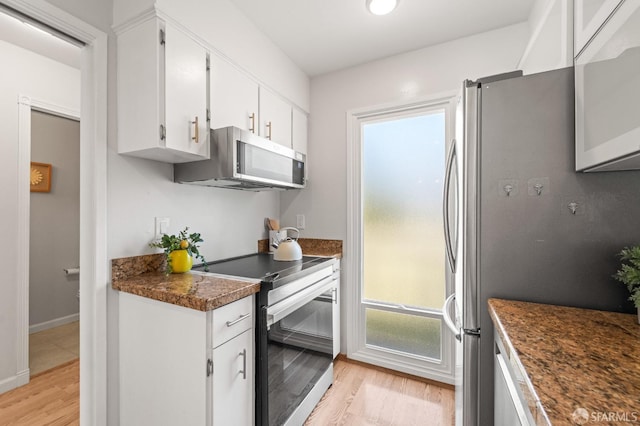 kitchen featuring appliances with stainless steel finishes, light wood-style flooring, plenty of natural light, and white cabinetry