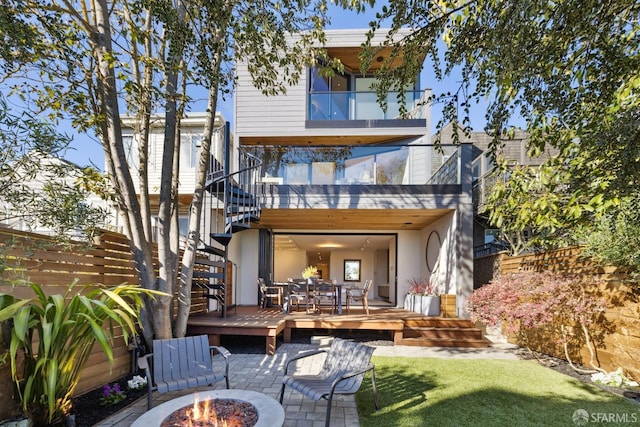 back of house featuring a balcony and a fire pit