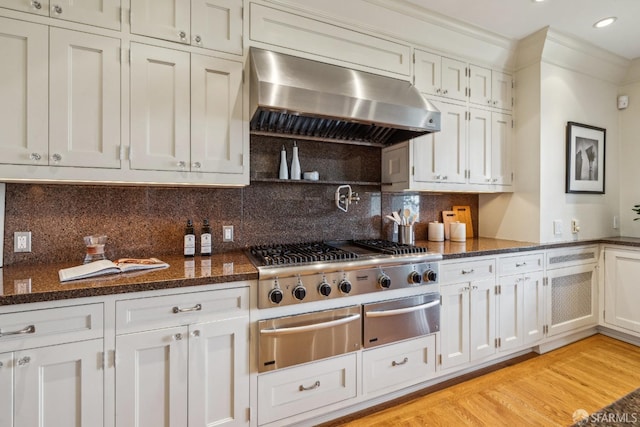 kitchen featuring tasteful backsplash, crown molding, light wood-style flooring, exhaust hood, and a warming drawer