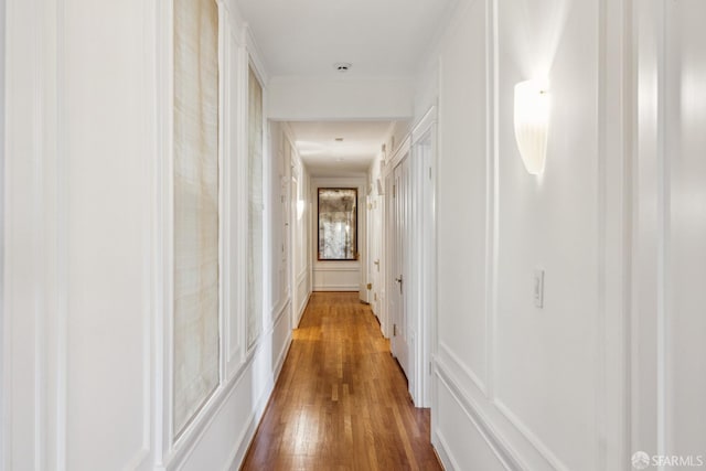 corridor featuring a decorative wall and wood finished floors