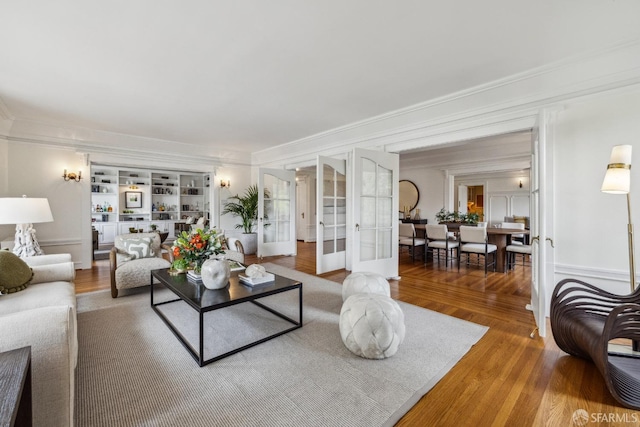 living area featuring french doors, wood finished floors, and ornamental molding