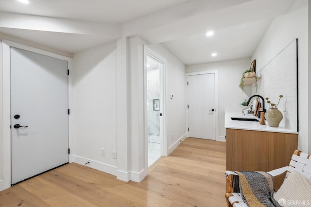 hallway with sink and light hardwood / wood-style floors