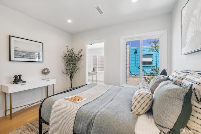 bedroom featuring hardwood / wood-style flooring and ensuite bathroom