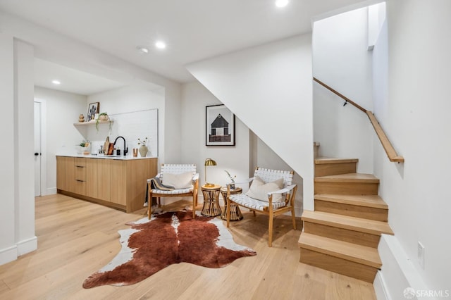 sitting room with sink and light hardwood / wood-style floors