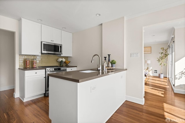 3044 Franklin St Unit 302, San Francisco, CA 94123 - kitchen with stainless steel appliances, a sink, dark countertops, dark wood finished floors, and tasteful backsplash
