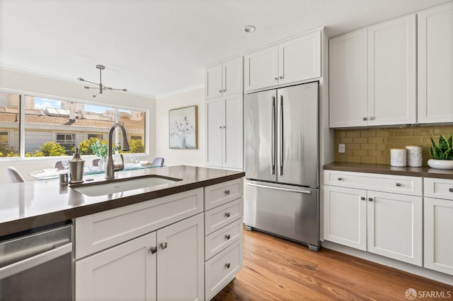 3044 Franklin St Unit 302, San Francisco, CA 94123 - kitchen featuring stainless steel appliances, dark countertops, a sink, crown molding, and white cabinets