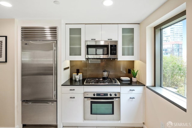 333 1st St Unit N307, San Francisco, CA 94105 - kitchen with appliances with stainless steel finishes, dark countertops, healthy amount of natural light, backsplash, and recessed lighting