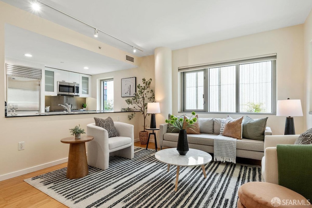 333 1st St Unit N307, San Francisco, CA 94105 - living room featuring rail lighting, wood finished floors, and recessed lighting