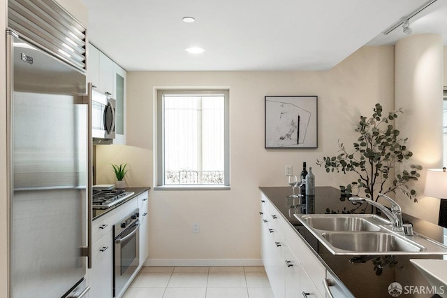 333 1st St Unit N307, San Francisco, CA 94105 - kitchen featuring stainless steel appliances, dark countertops, white cabinetry, light tile patterned floors, and recessed lighting