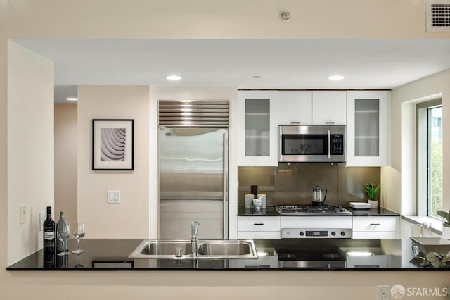 333 1st St Unit N307, San Francisco, CA 94105 - kitchen featuring stainless steel appliances, dark countertops, white cabinetry, tasteful backsplash, and recessed lighting