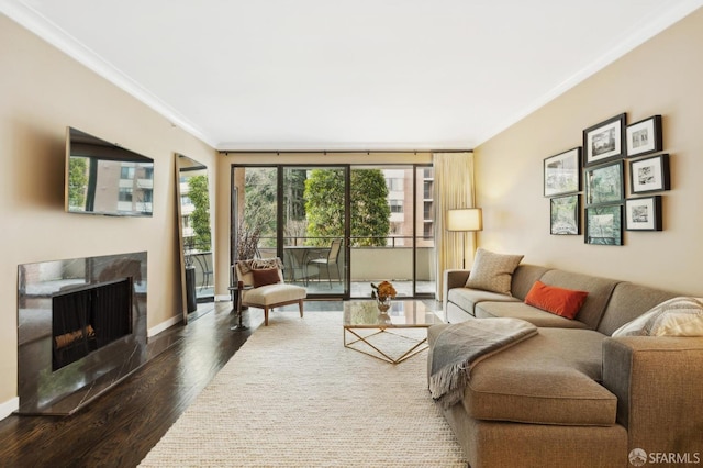 living area with plenty of natural light, ornamental molding, dark wood-type flooring, and a high end fireplace