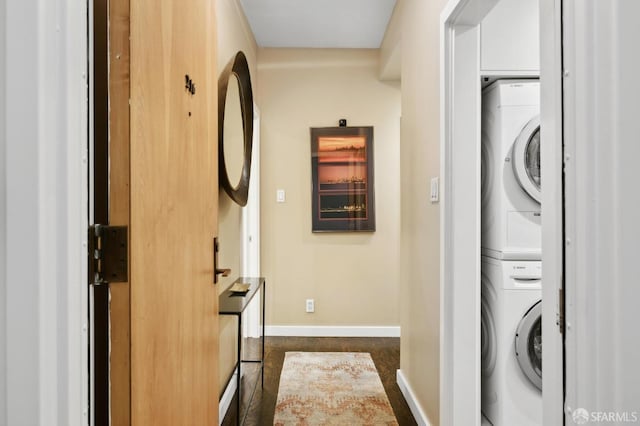 laundry area with stacked washer and dryer, laundry area, and baseboards